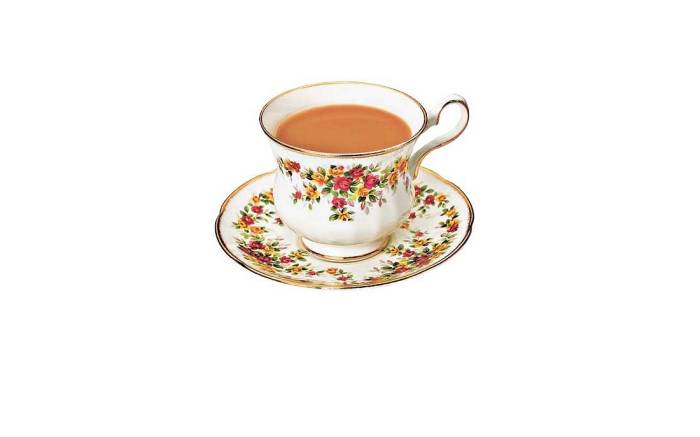 Vintage rose tea cup filled with milky tea