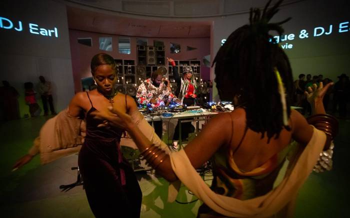 group of people dance in front of DJ booth