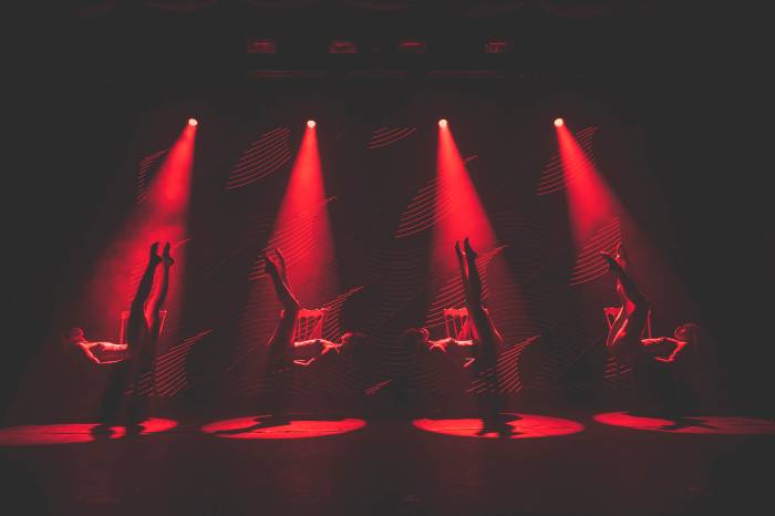 four Tryst Caberet dancers bathed in red spotlights