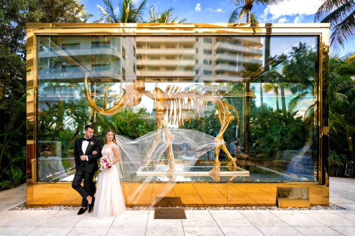 bride and groom stand in front of mammoth statue