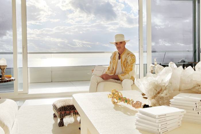 Alan Faena sitting by a balcony over the ocean 