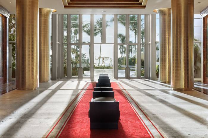 long lobby hallway with six golden columns