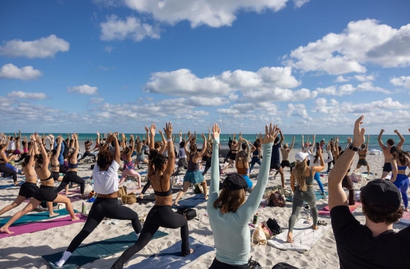 Group of people doing pilates on the beach