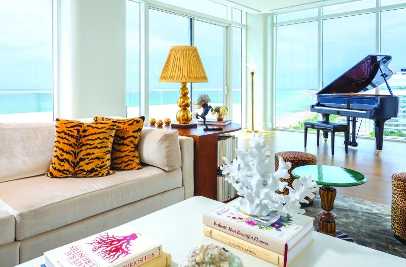 couch in hotel penthouse with grand piano behind