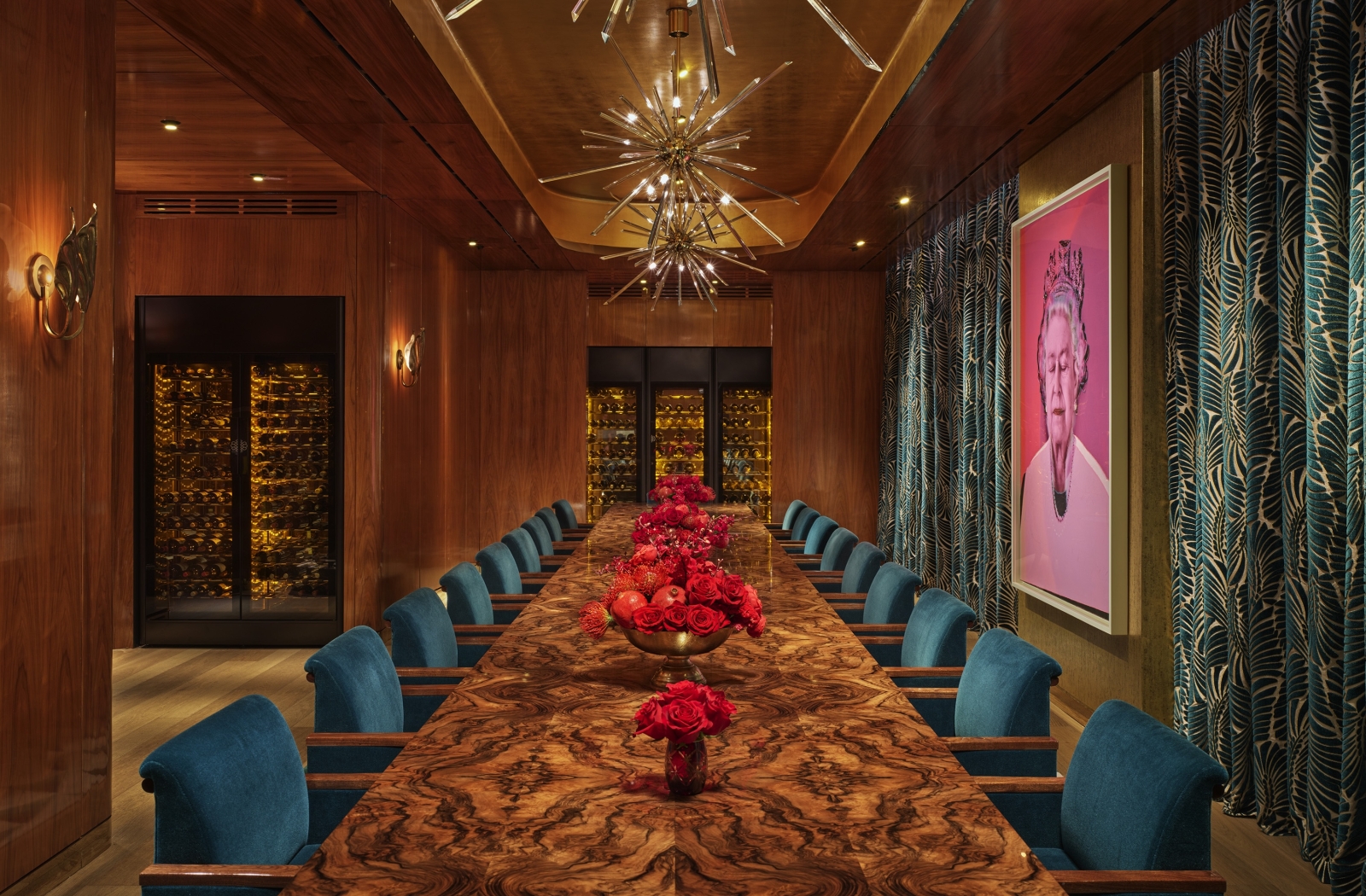 An eclectic private dining room with a long table and a pop art painting of Queen Elizabeth