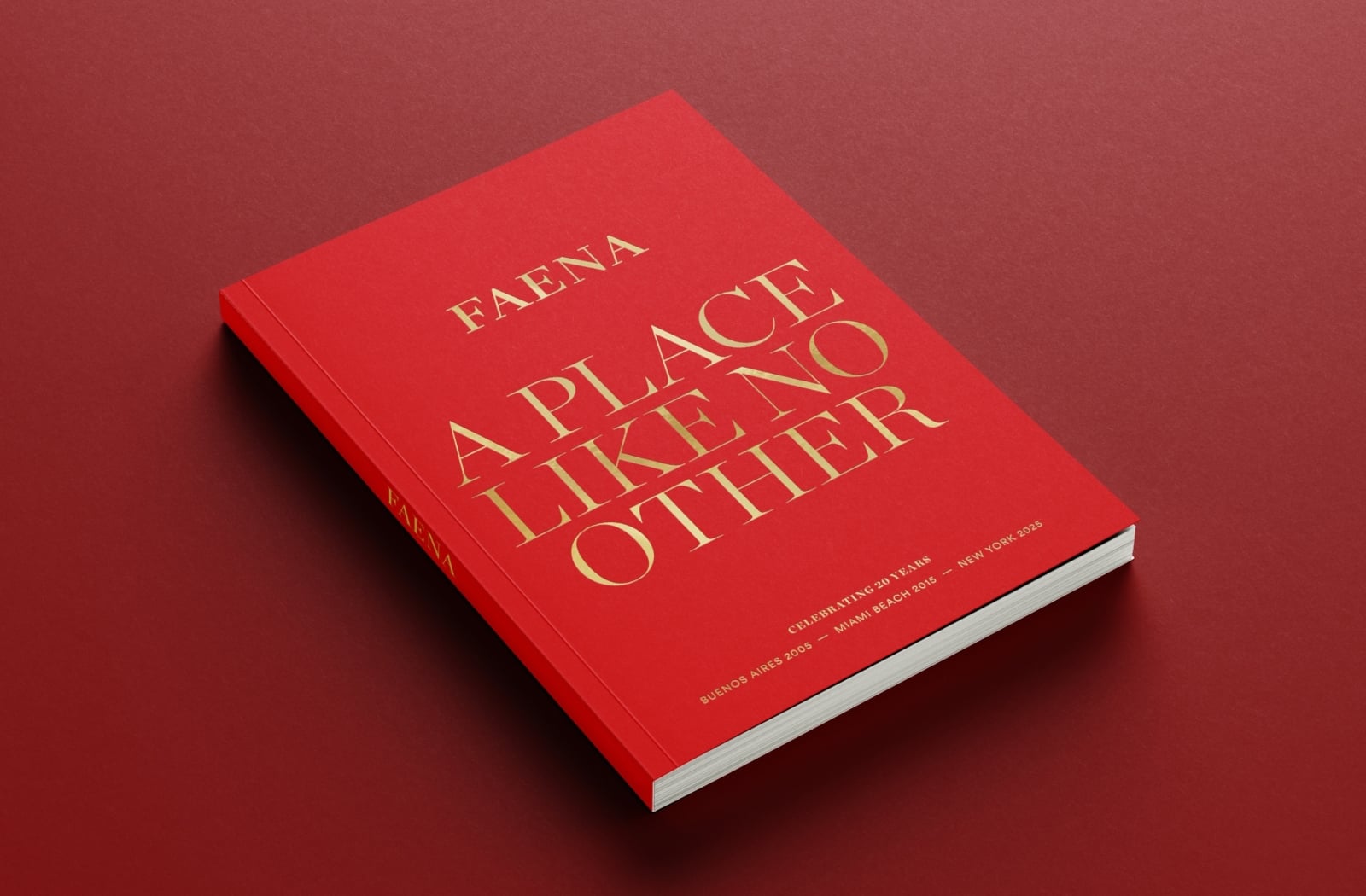 Red Faena coffee table book titled “A Place Like No Other,” featuring elegant gold lettering celebrating 20 years of Faena.