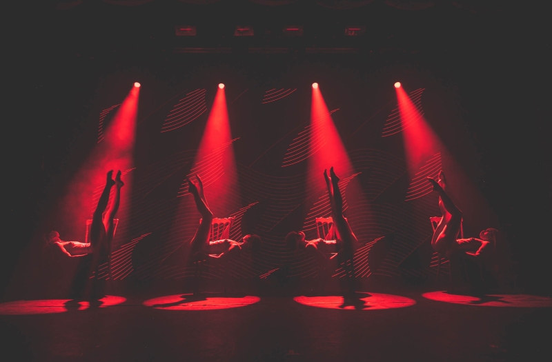 four Tryst Caberet dancers bathed in red spotlights