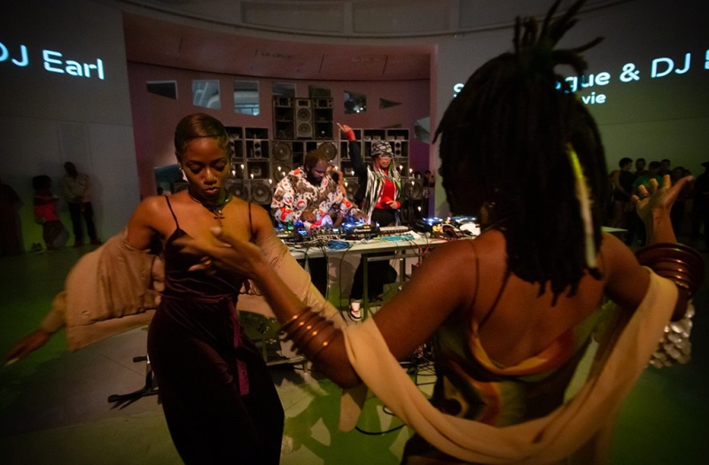 group of people dance in front of DJ booth