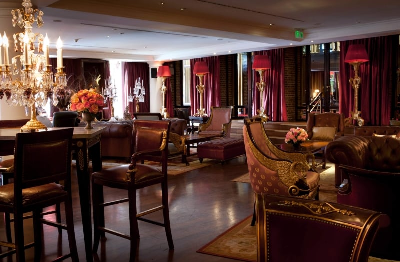 interior of lounge with red curtains, lamps and large candelabra on table