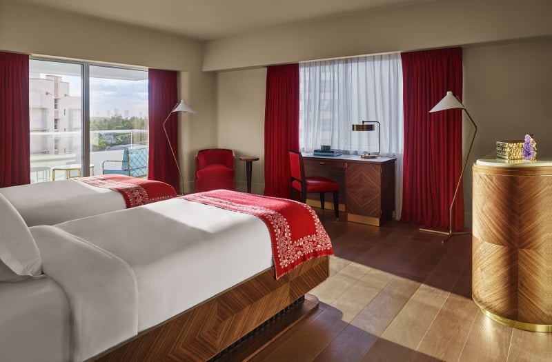 hotel bedroom with large windows overlooking city