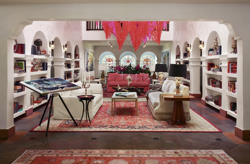 furniture sits on rug in room with red chandelier 