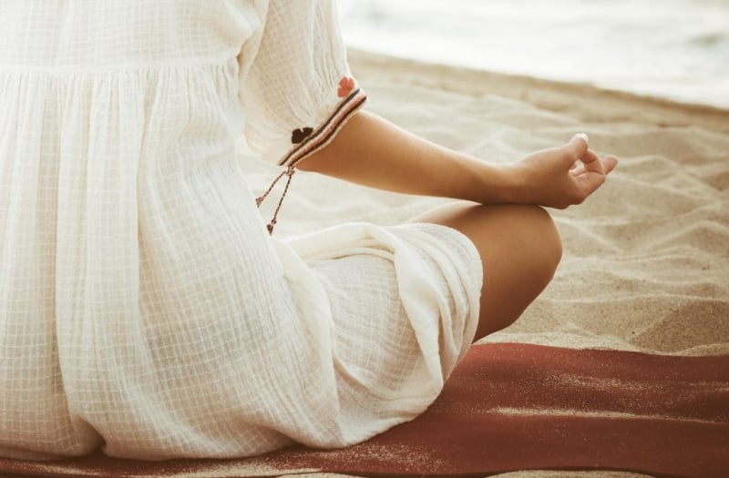 Woman meditating on beach