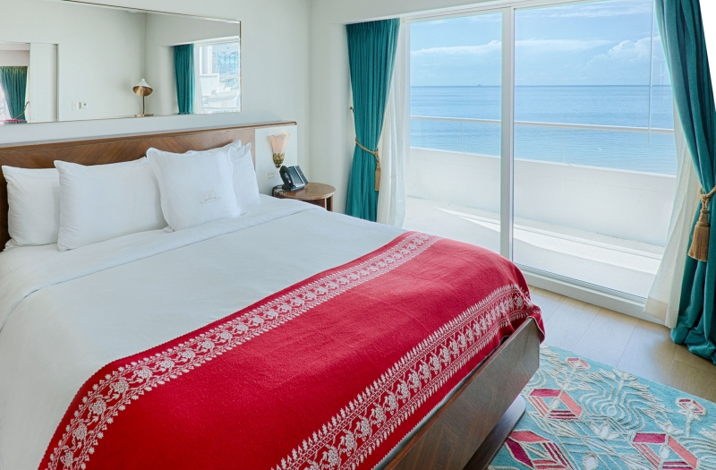 bedroom with patio door with ocean in background