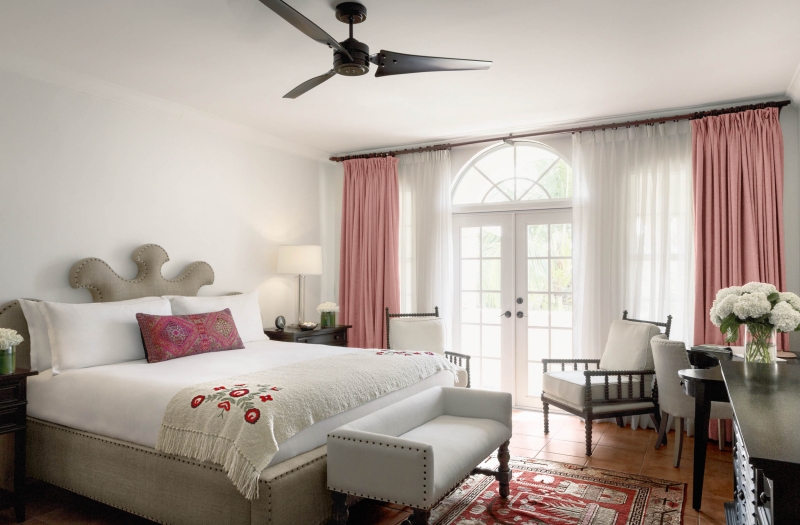king bed with white sheets and pink pillows