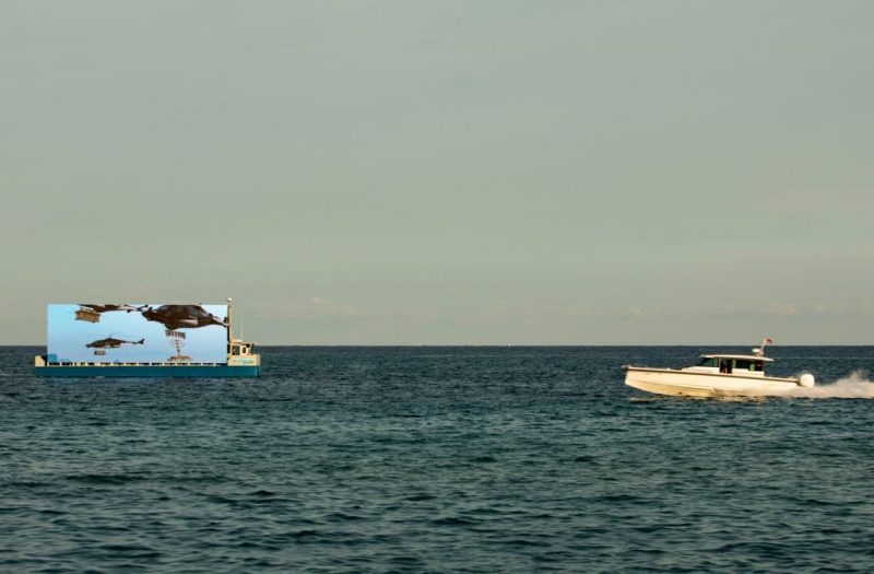 film showing floating screen off shore of Miami Beach