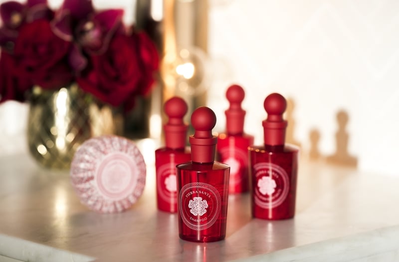 Bath products in red bottles sitting on a white counter
