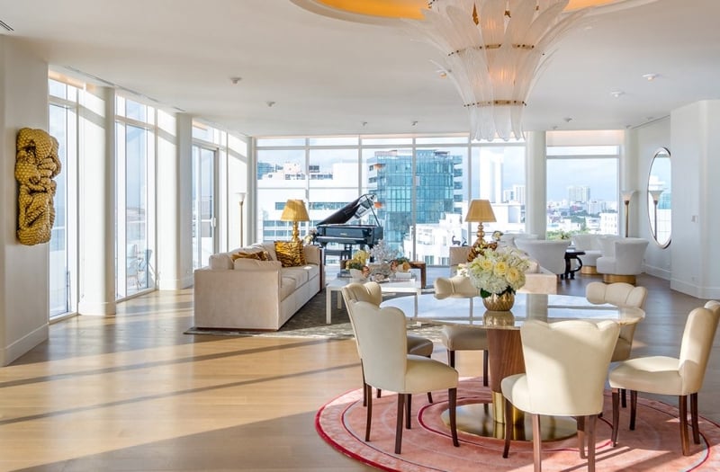 large hotel penthouse with living space and grand piano in the distance