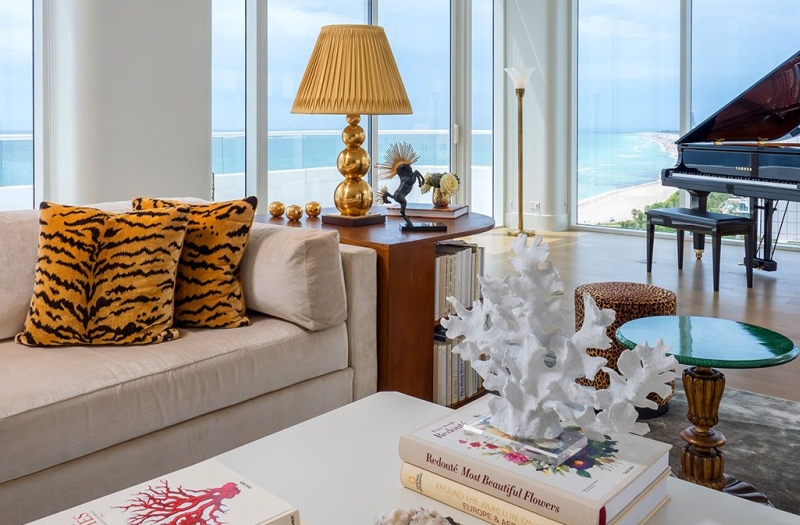 couch in hotel penthouse with grand piano behind
