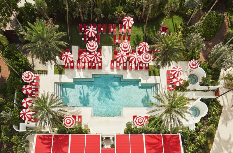 hotel pool with sun umbrellas and palm trees
