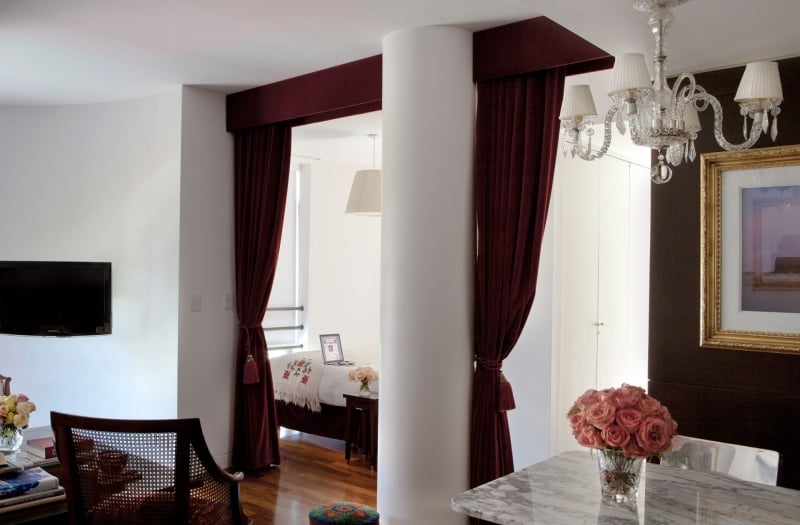 hotel studio room with large column and velvet curtains