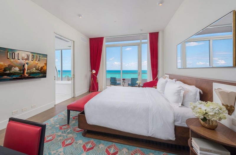 Bedroom with balcony, bathroom, and desk