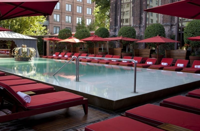 pool surrounded by red lounge chairs