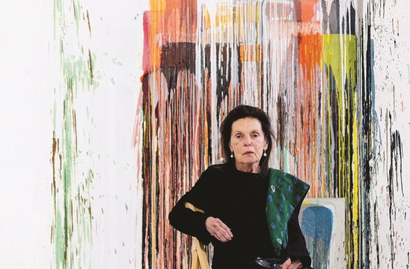 Woman sitting in front of abstract painting