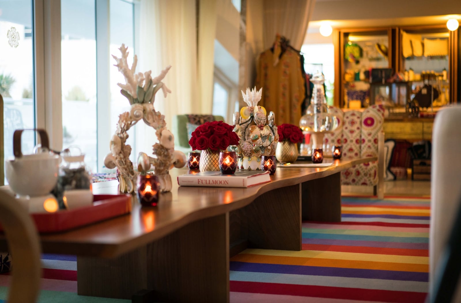 long table with candles and a rainbow rug underneath