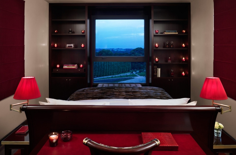 suite hotel bed facing windows with bookshelves