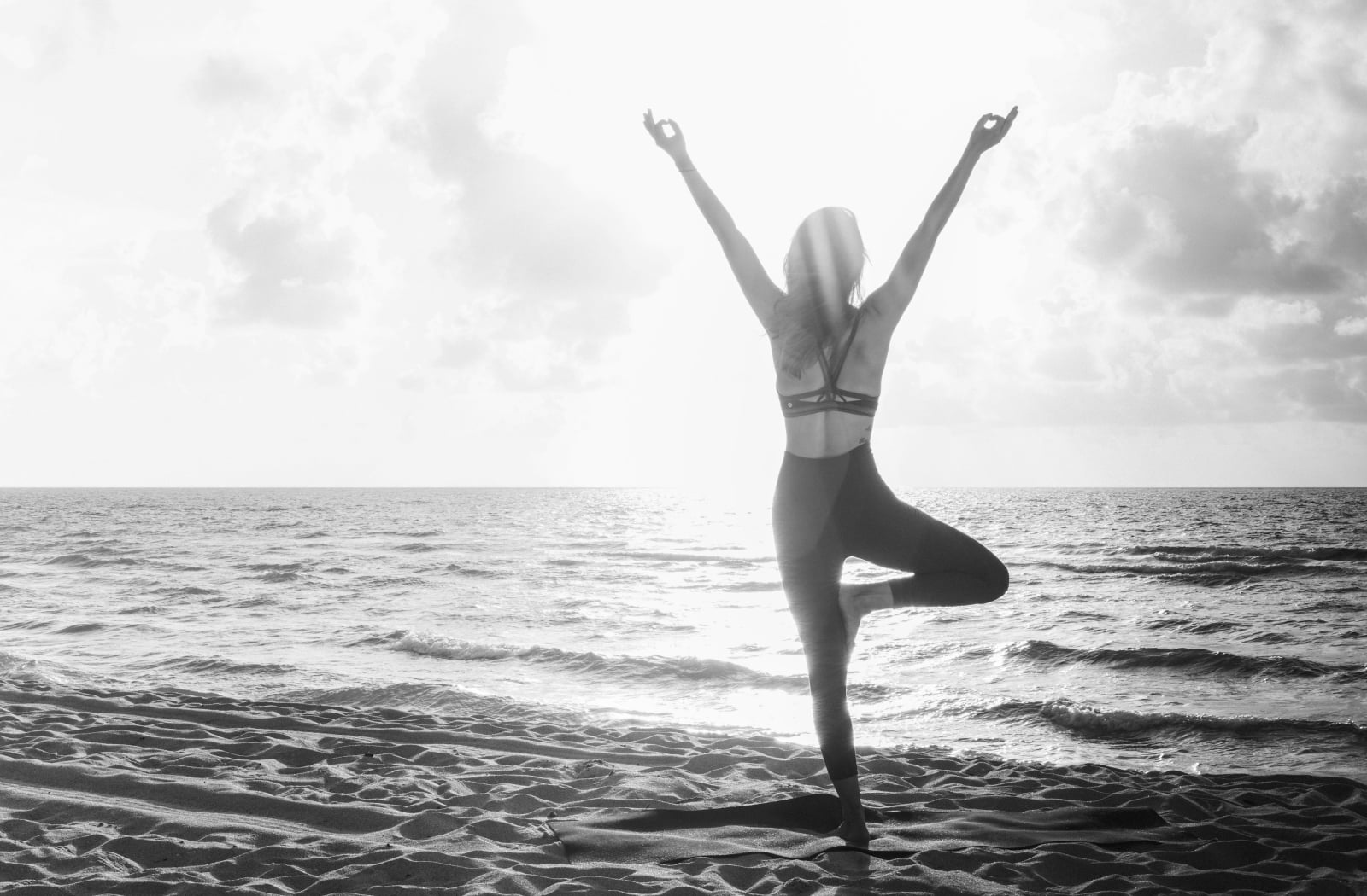 woman on beach holding a yoga pose
