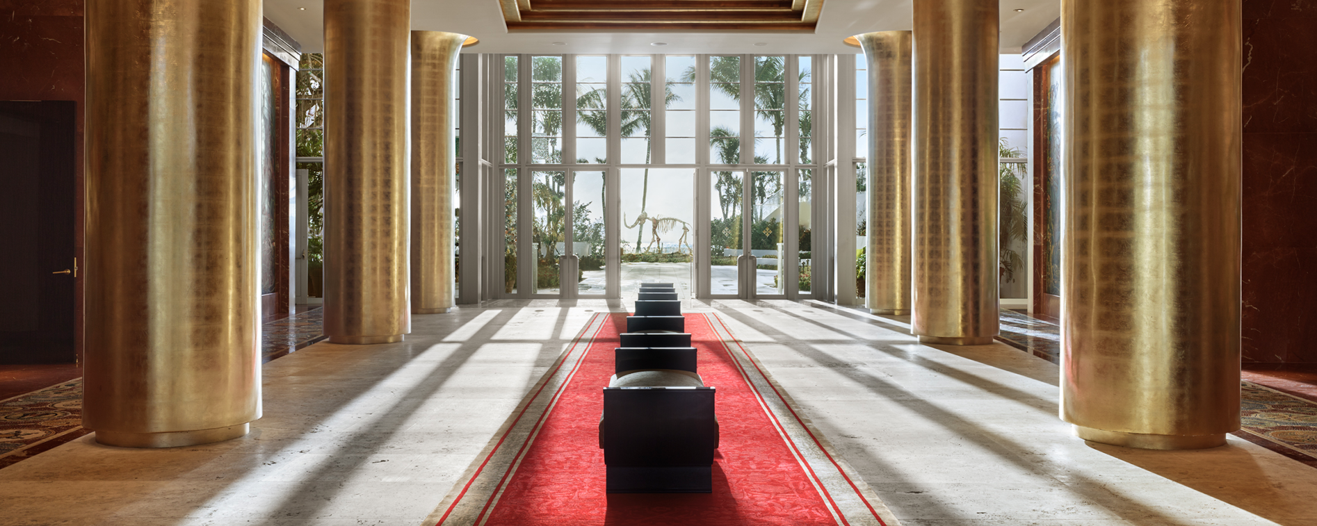 long lobby hallway with six golden columns