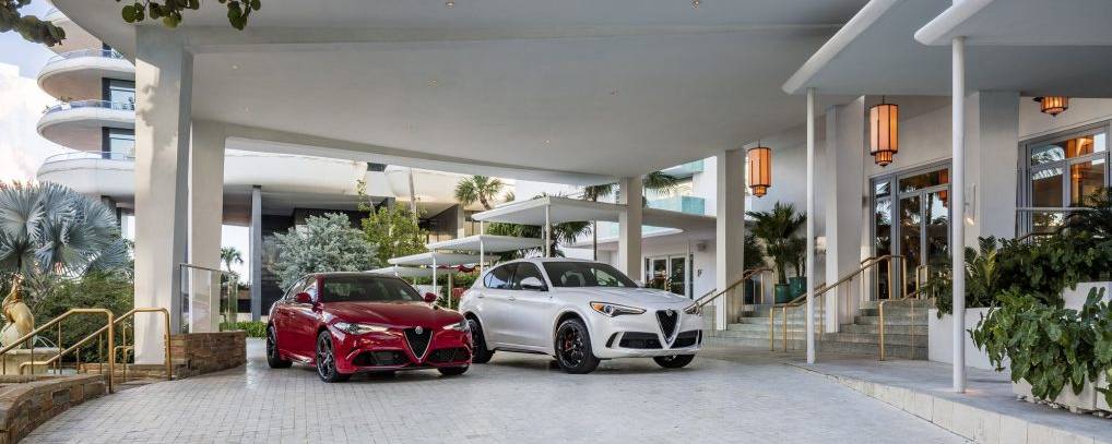 Red and white alfa romeo cars parked in front of Faena hotel