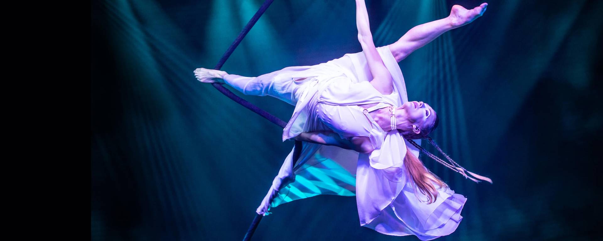 woman in white performs aerial trick on rope