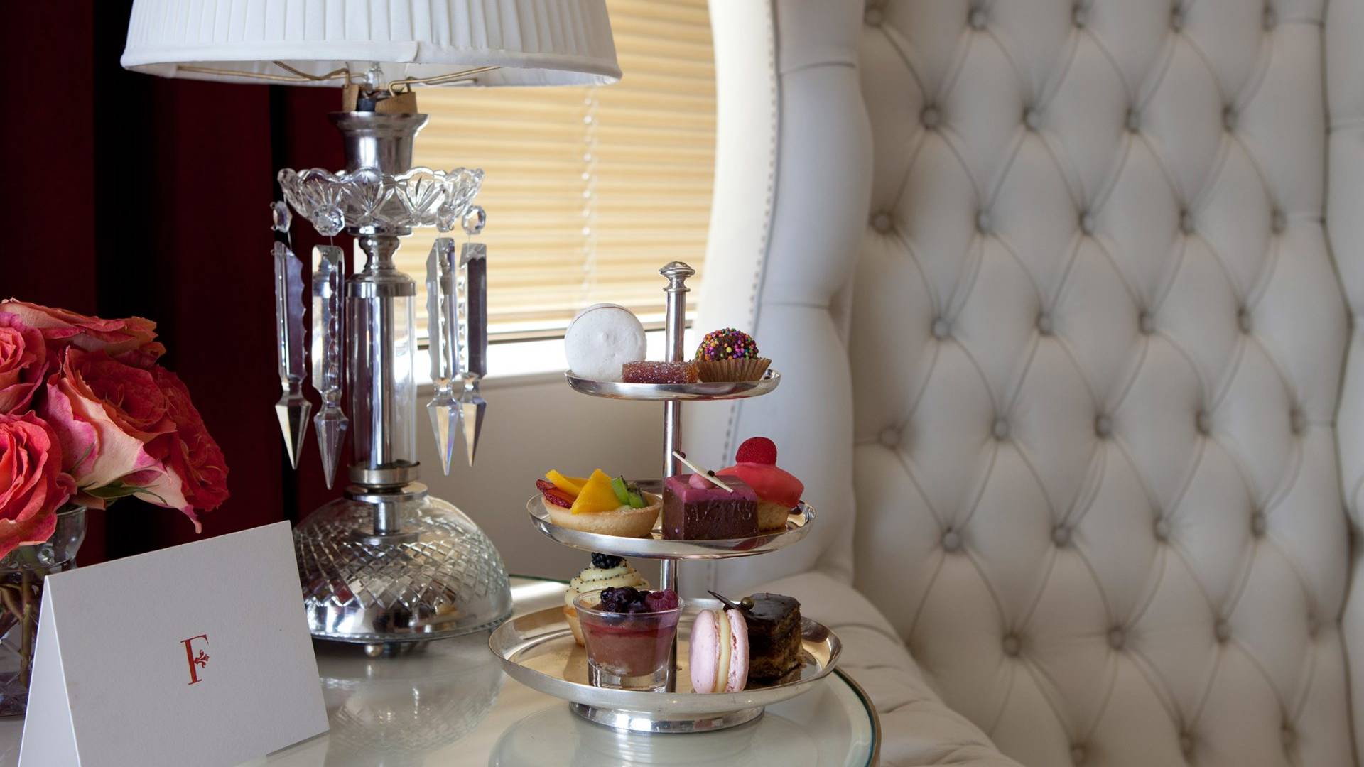 three tiered tray with snacks on hotel bedside table