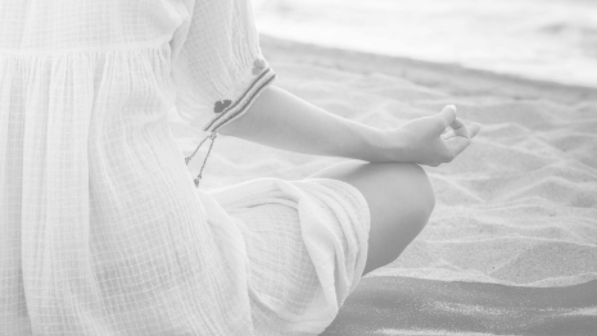 woman on beach sitting in lotus position