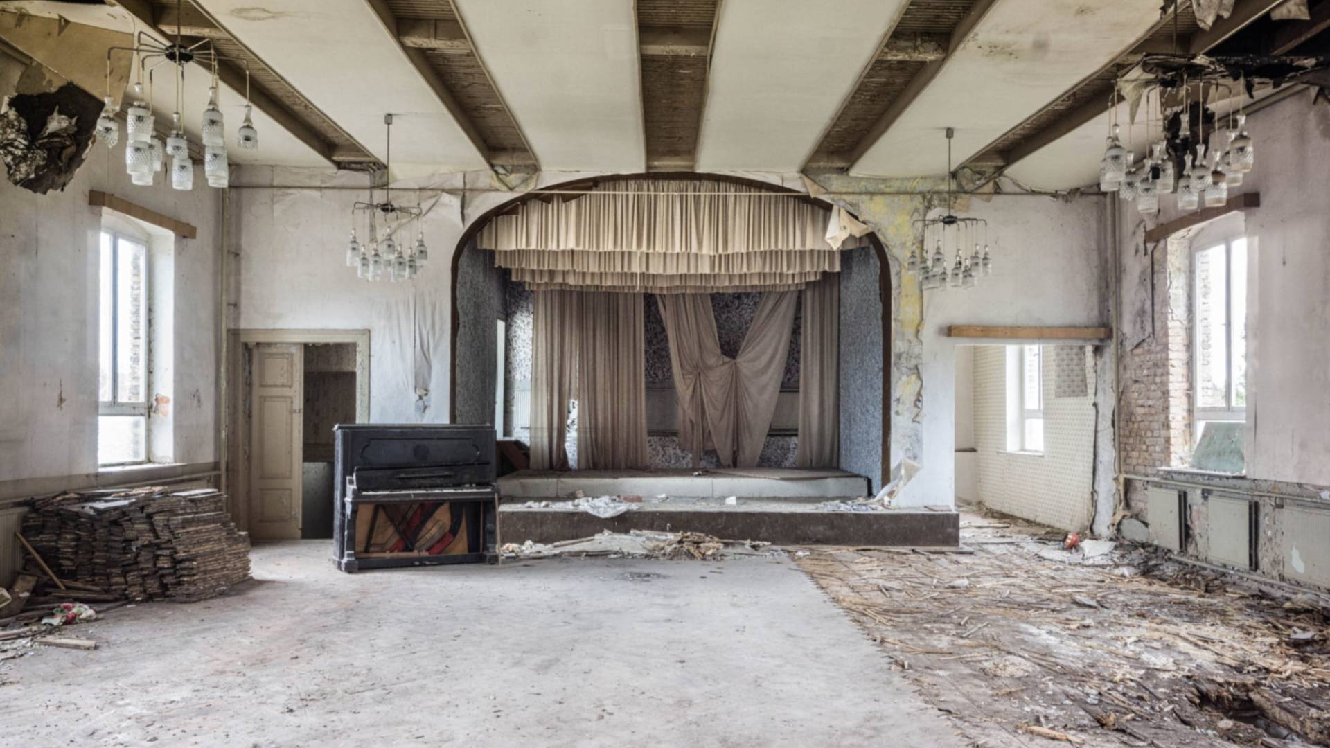 Piano sits in abandoned room in front of stage.