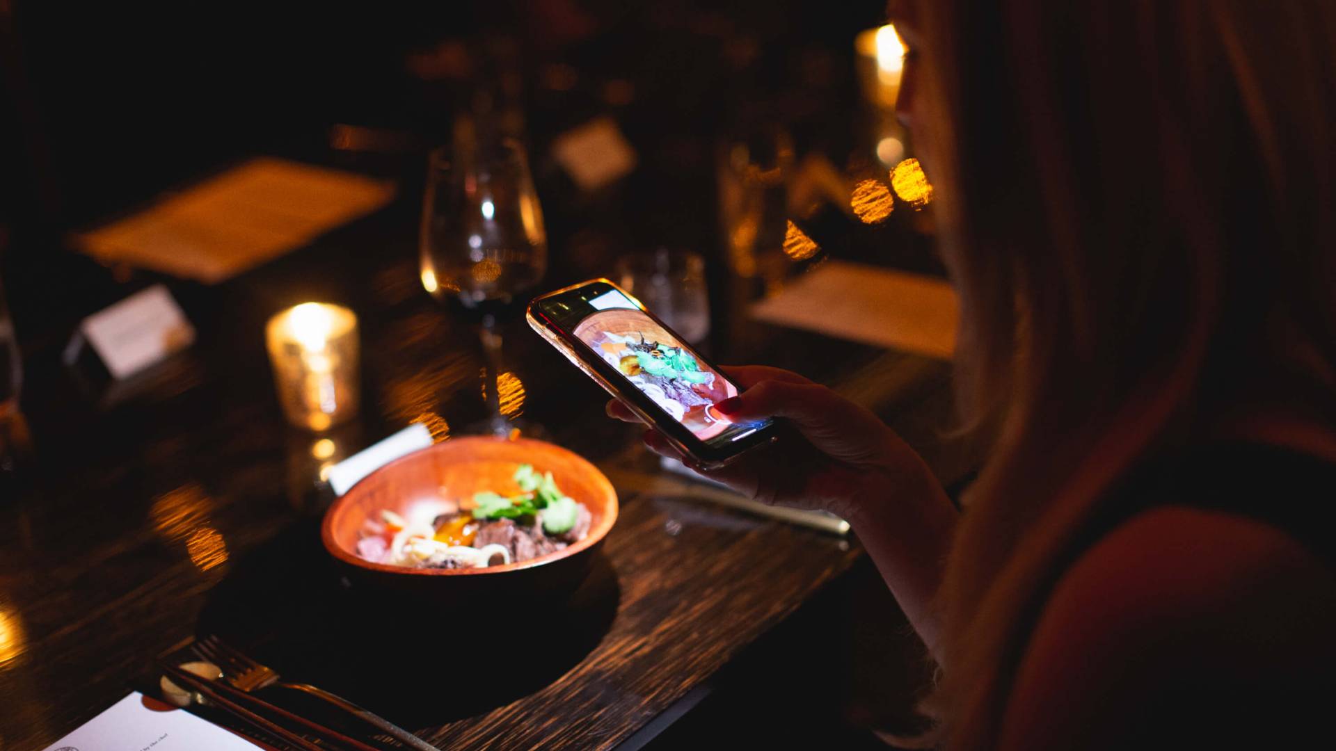 woman taking a photo of her meal at la cava