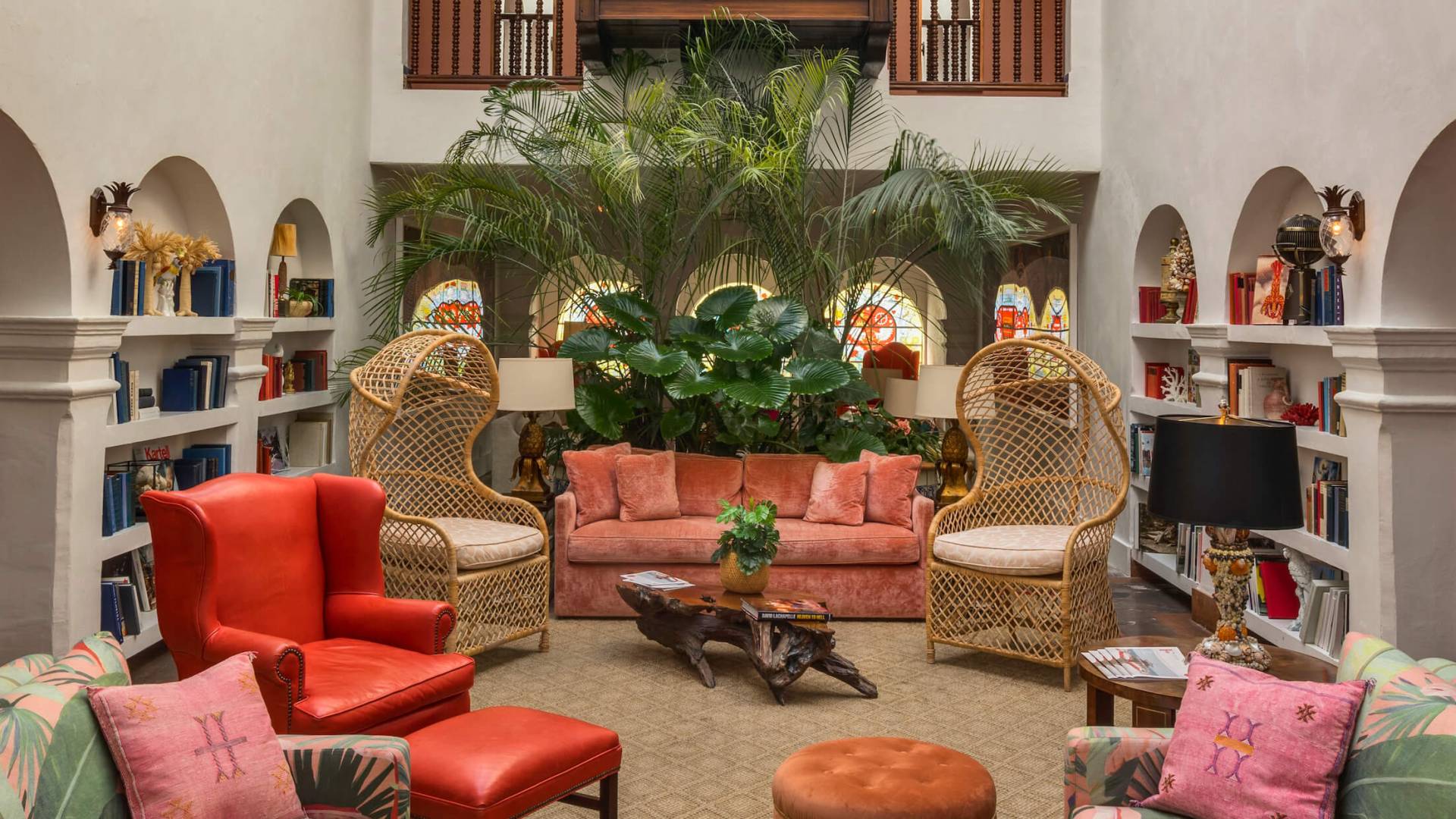 atrium of hotel filled with red, pink, green, and wicker furniture