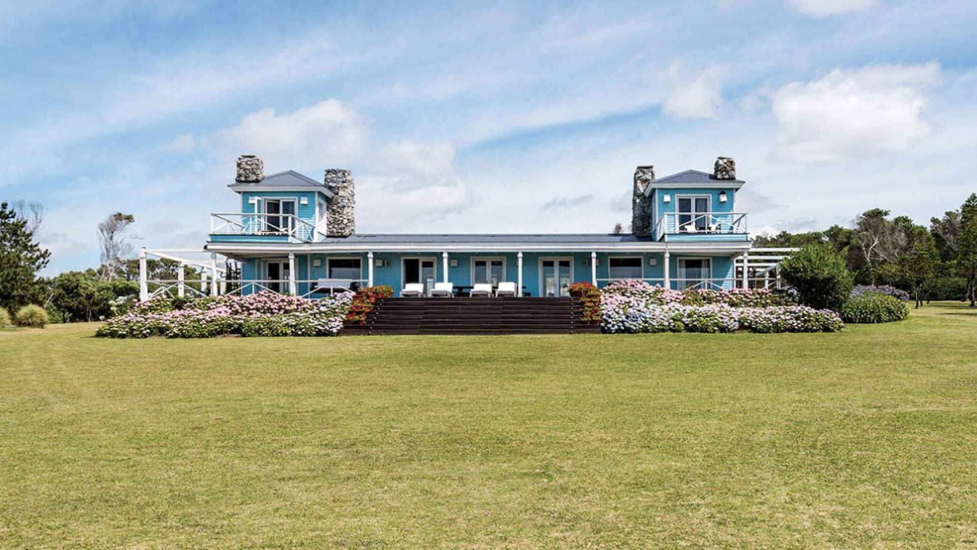 blue house sits on green lawn