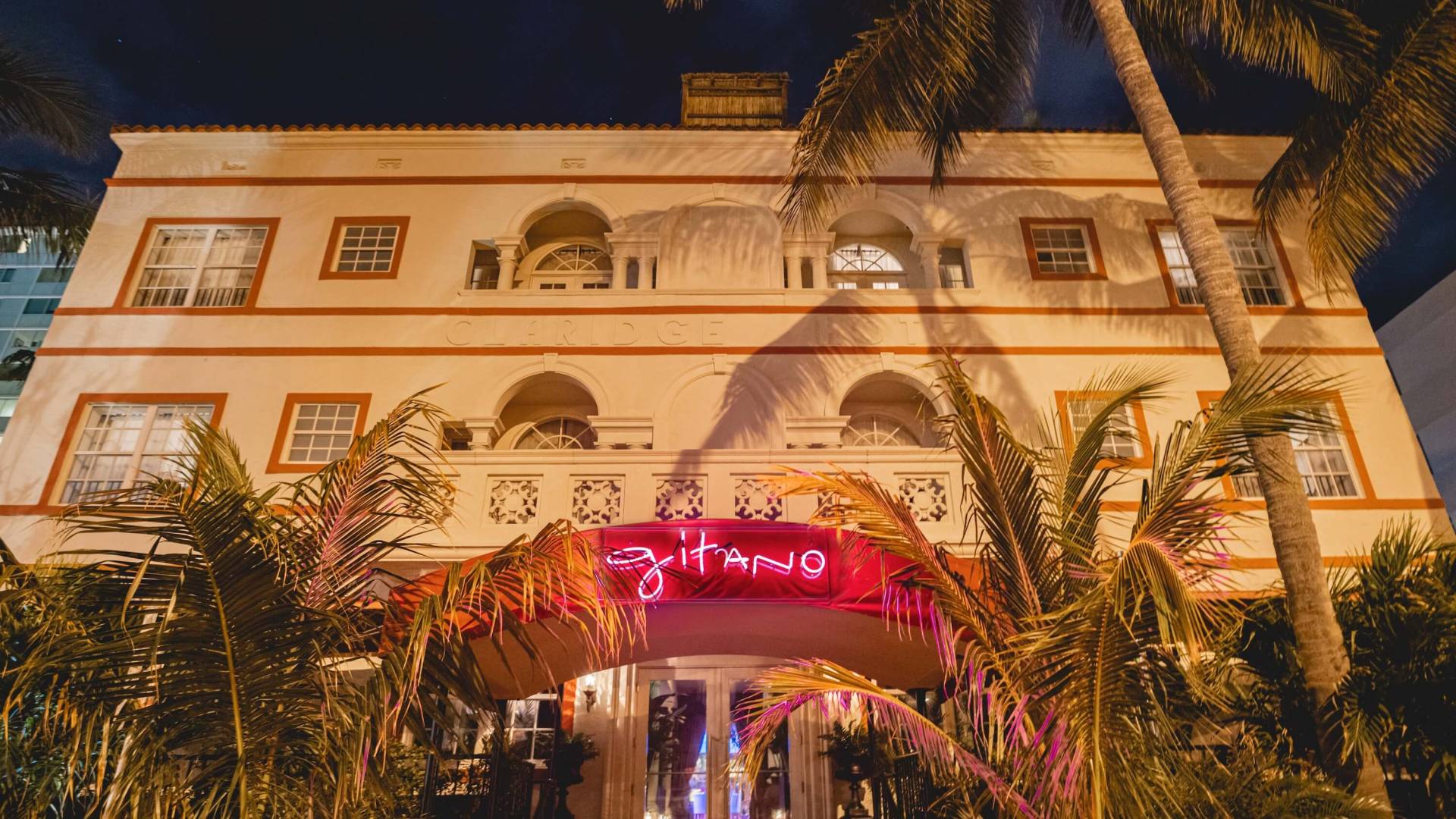 exterior front-side of Gitano MIami with lit-up pink neon sign