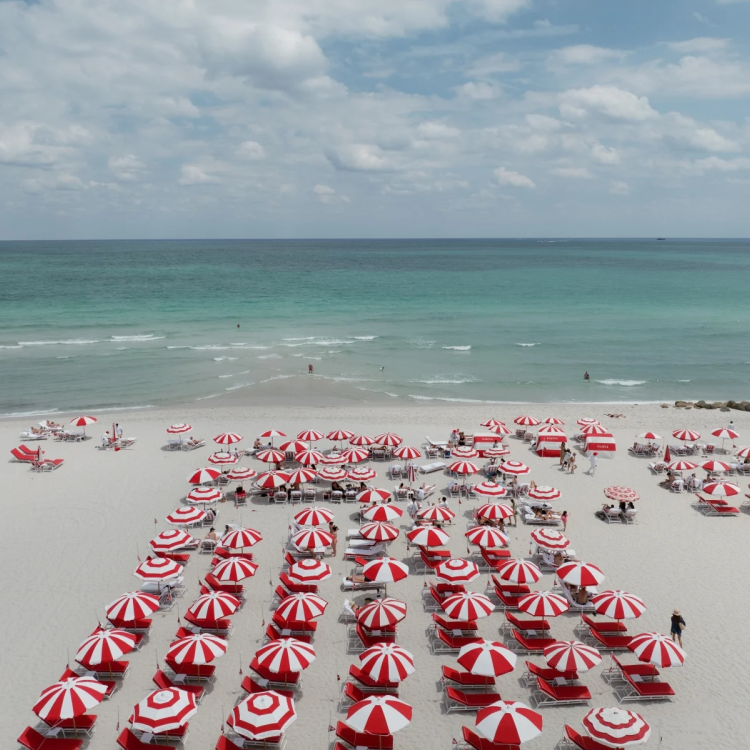 Aerial of Beach with red and white stripped umbrellas