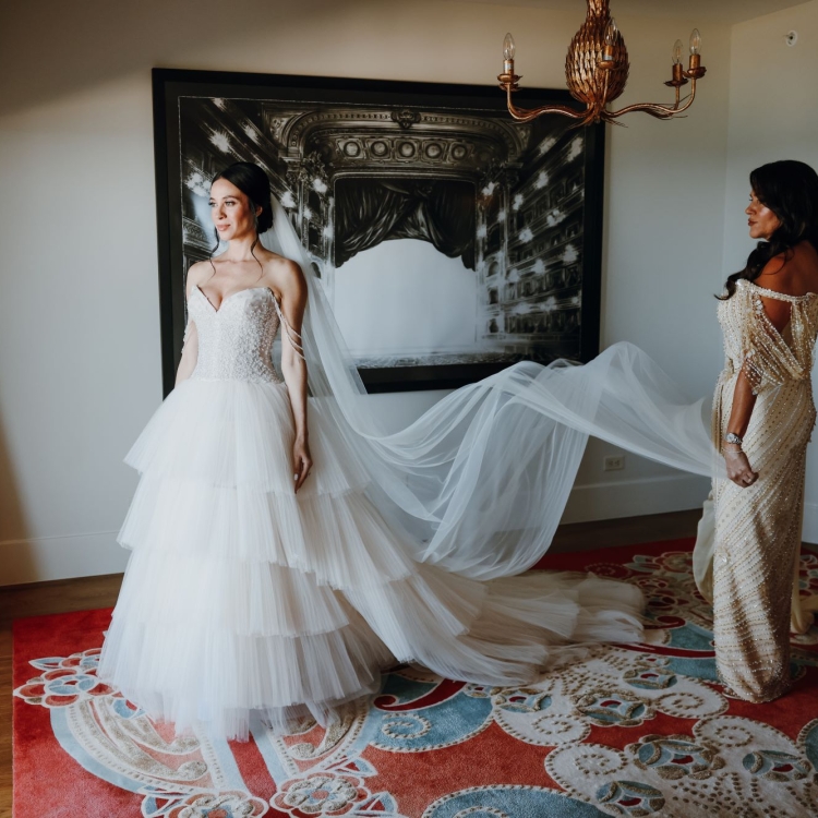 Angie in her dress with her mom holding the veil