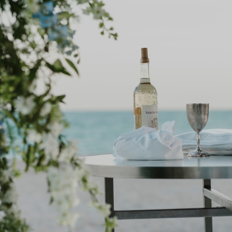 Table on the beach with items for the ceremony.