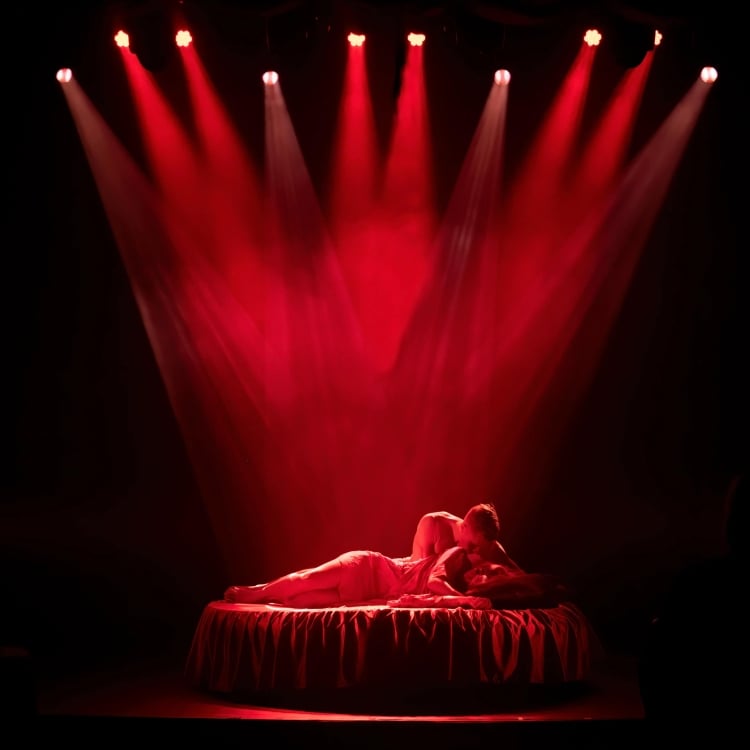 Couple in bed under spotlights
