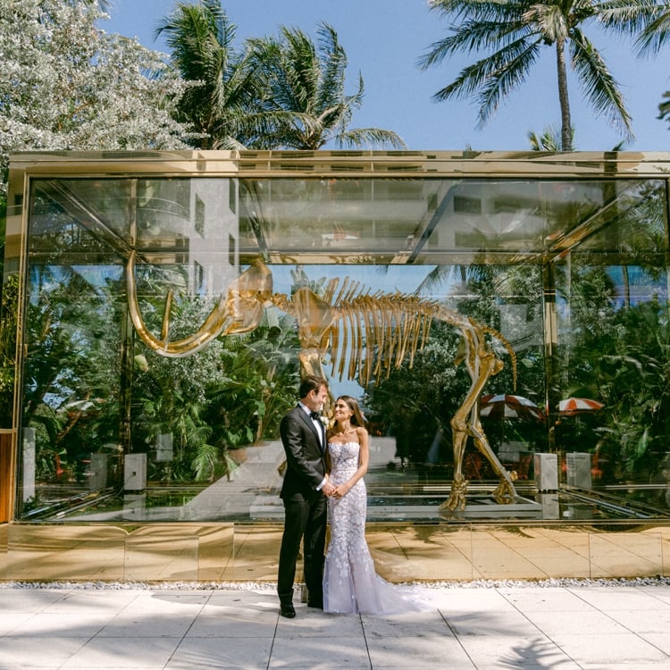 Allison and Robert Zale smiling at each other in front of the gold mammoth