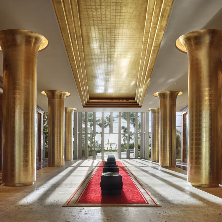 long lobby hallway with six golden columns