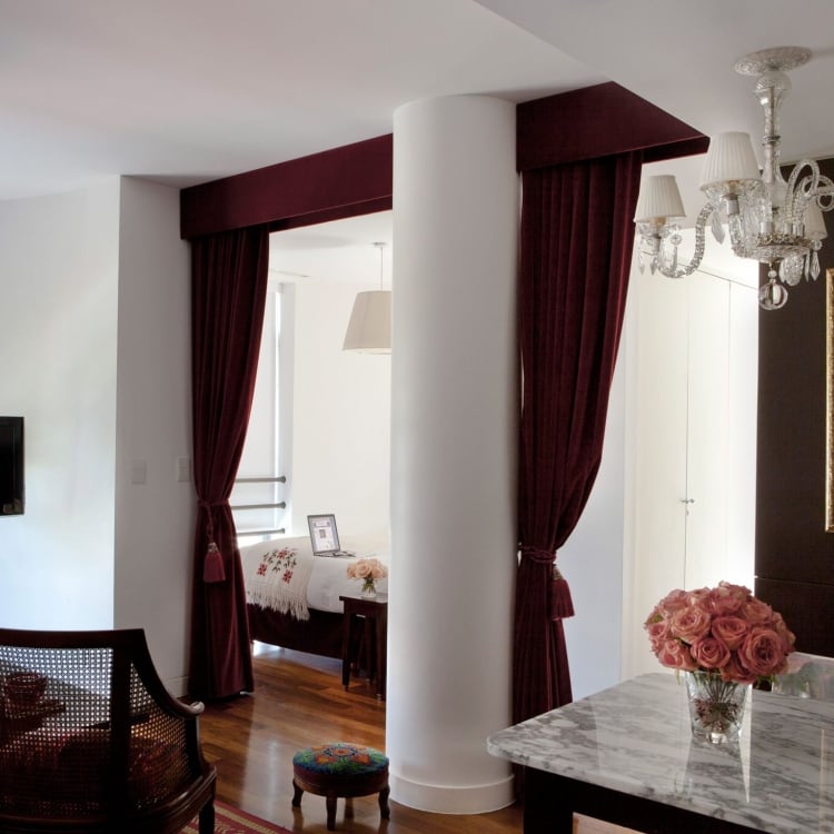 hotel studio room with large column and velvet curtains