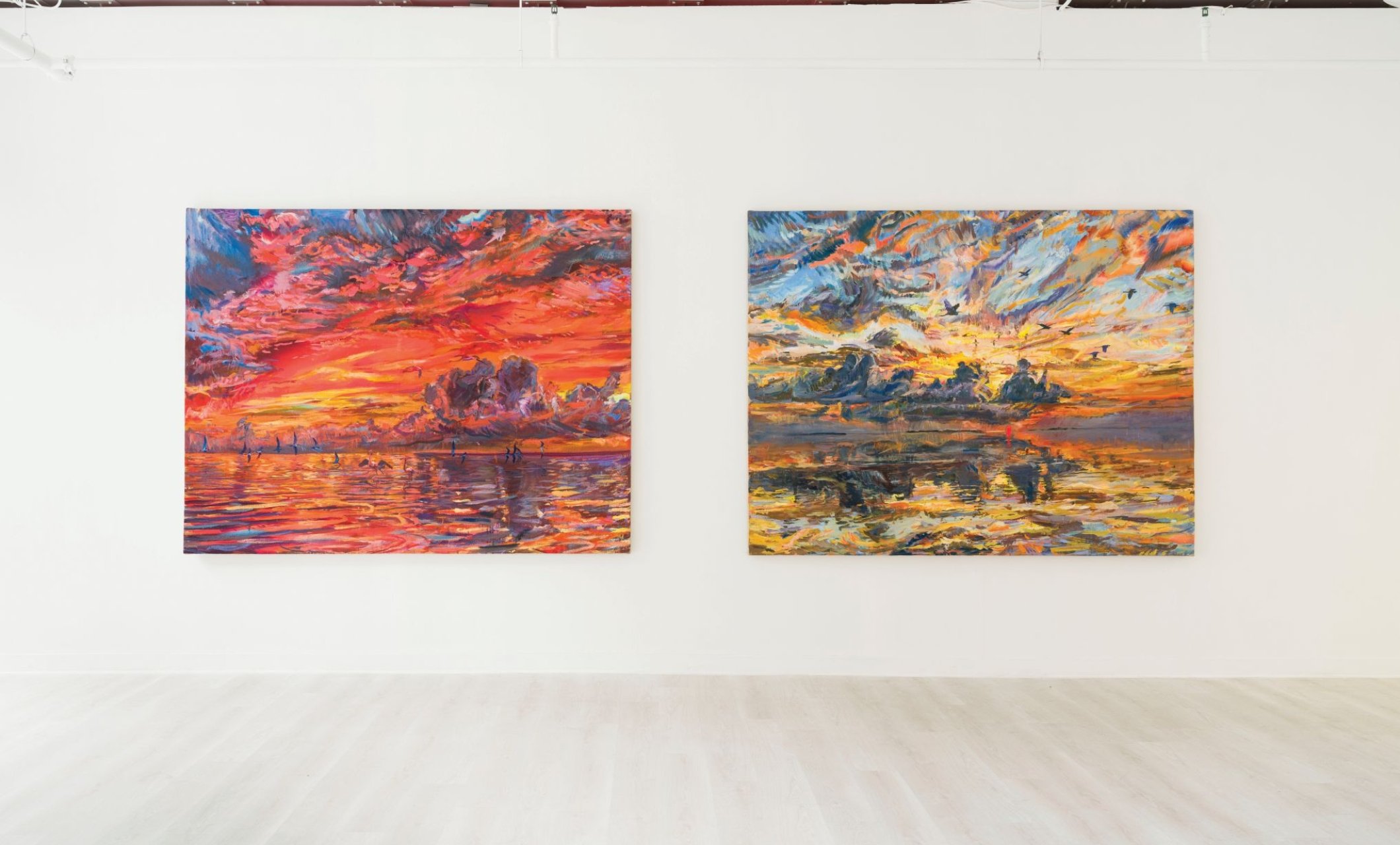 two paintings hanging in a gallery