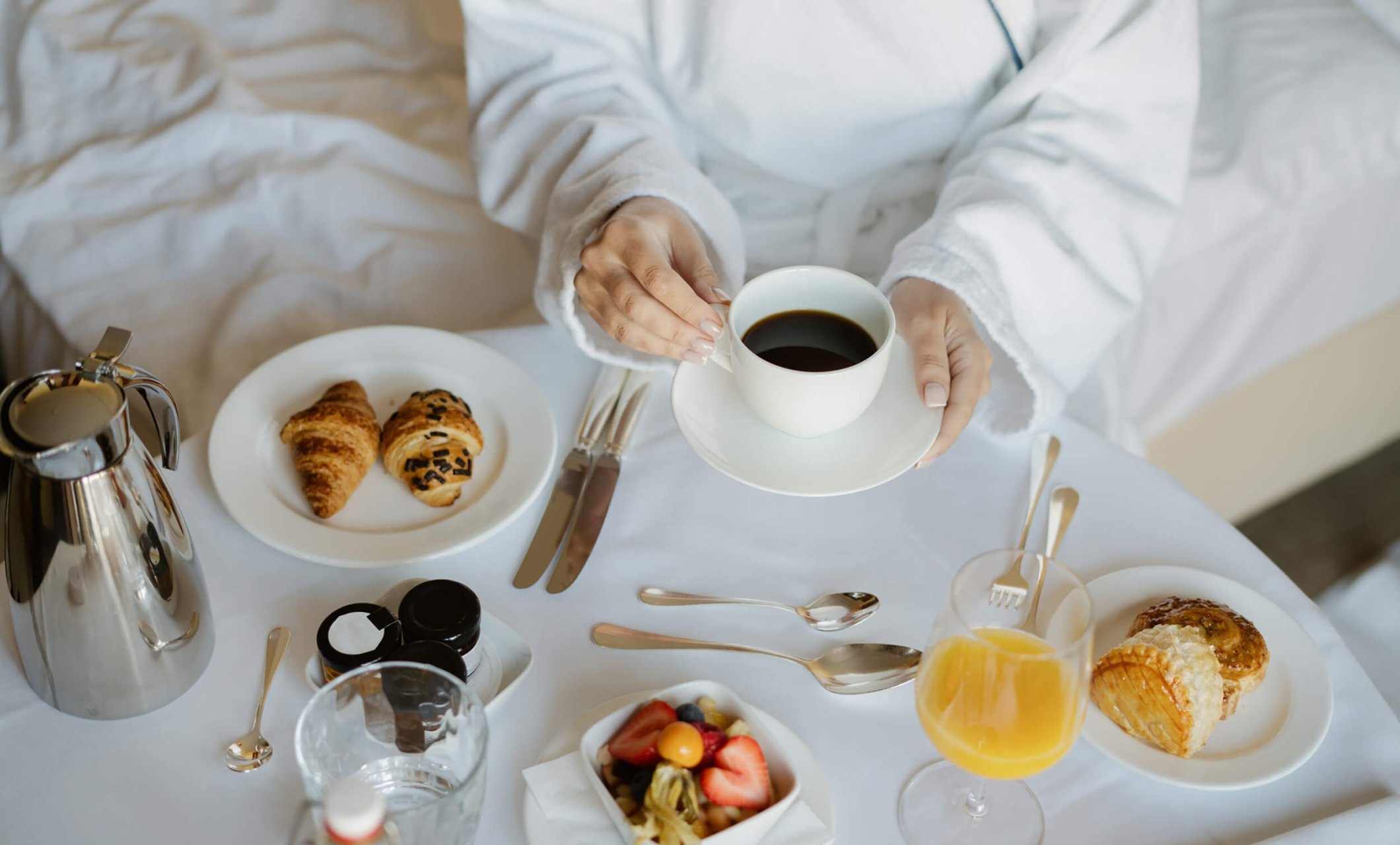 A woman selecting coffee from a room service tray