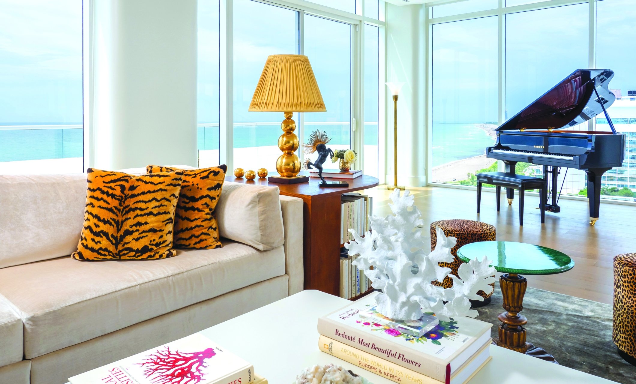 couch in hotel penthouse with grand piano behind